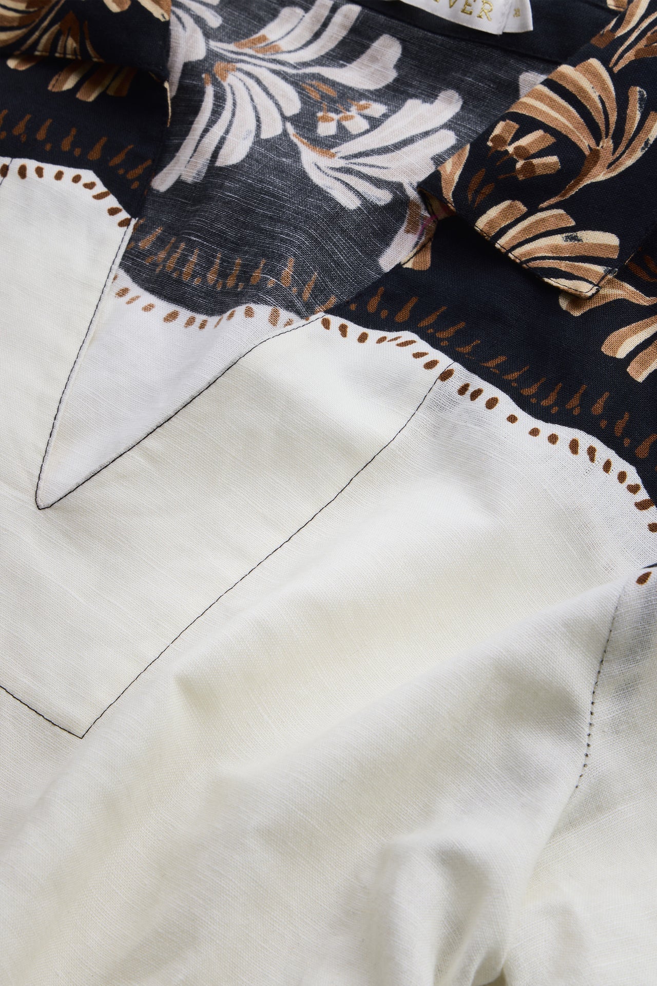 Close-up of a shirt with floral embroidery on a dark background