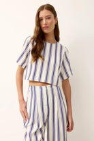 Woman wearing a blue and white striped dress against a white background