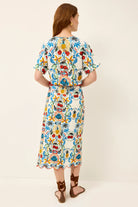 Woman wearing a colorful floral dress on a white background