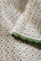 Close-up of a crocheted blanket with a green border