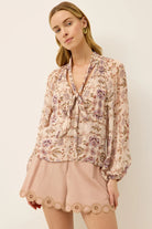 Woman wearing a floral blouse with a plain background