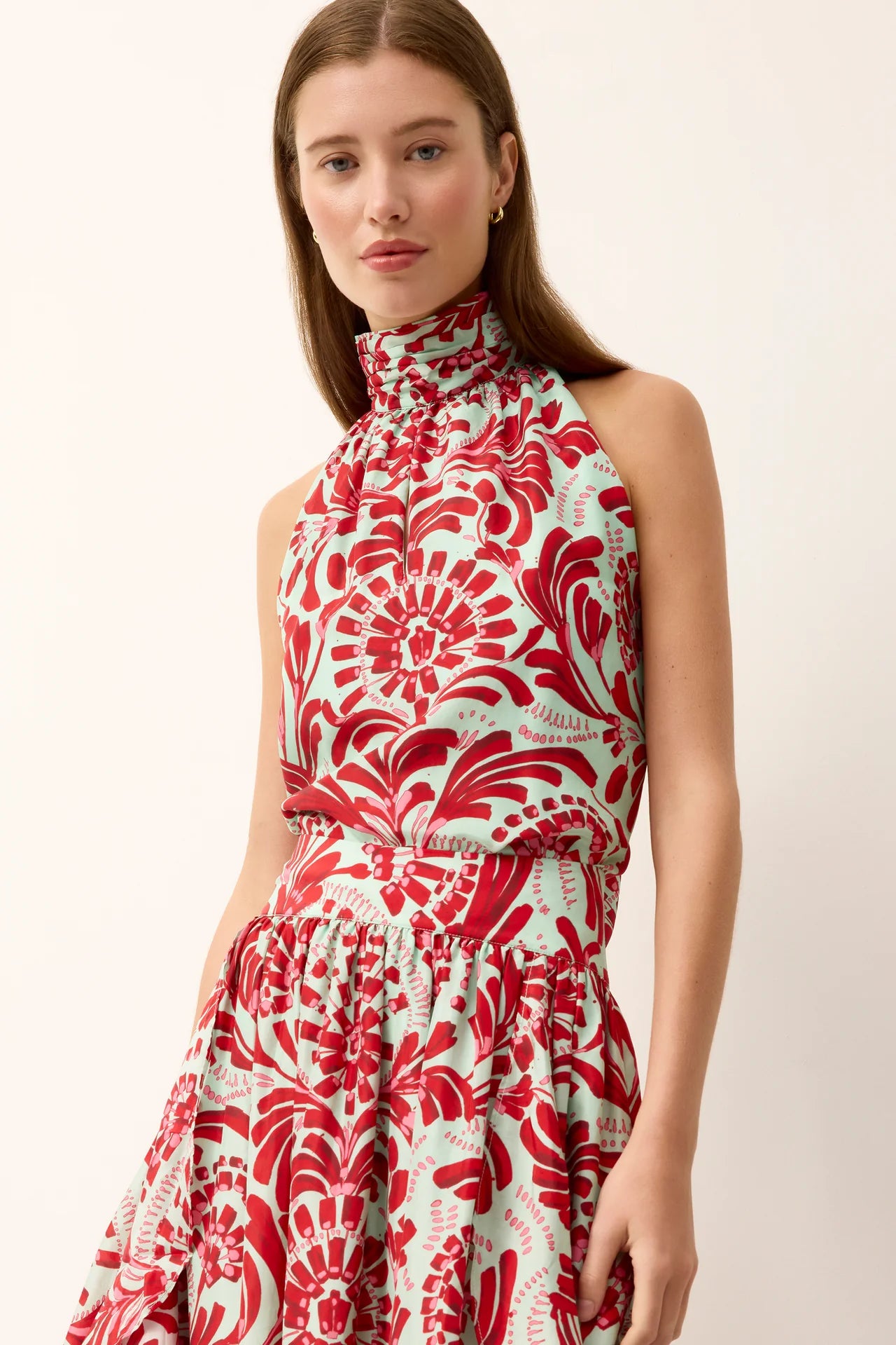 Woman wearing a red and white patterned dress against a plain background