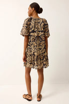 Woman wearing a patterned dress on a white background
