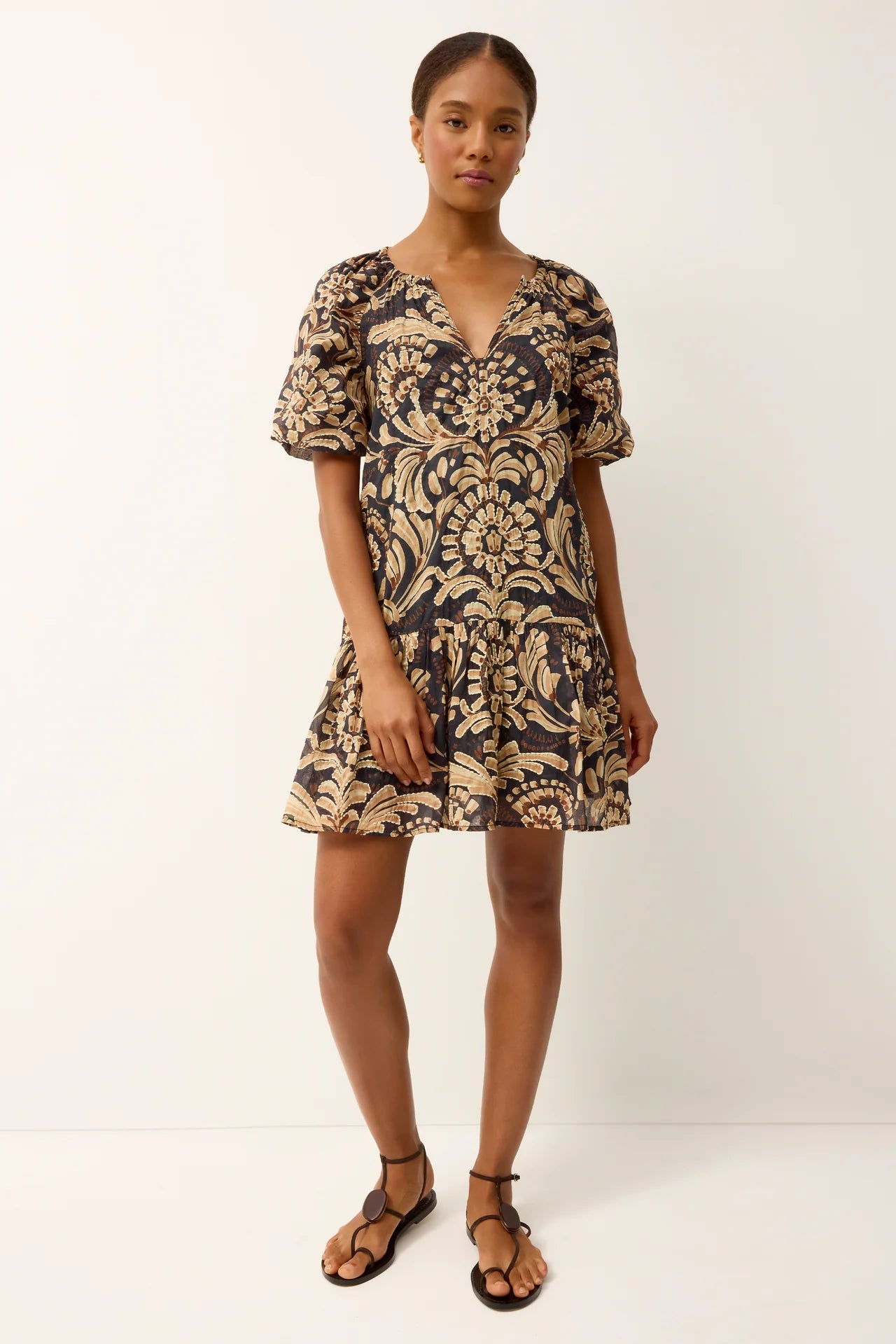 Woman wearing a patterned dress on a white background