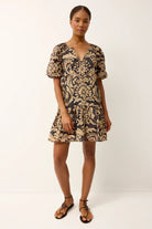 Woman wearing a patterned dress on a white background