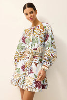 Woman wearing a floral dress against a plain background