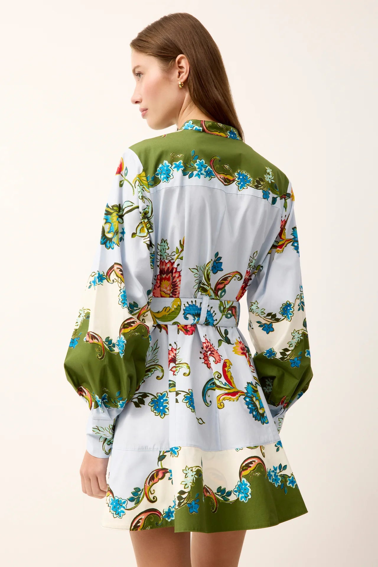 Woman wearing a colorful patterned dress on a white background