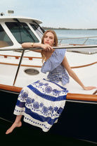 Woman in a blue and white dress sitting on a boat