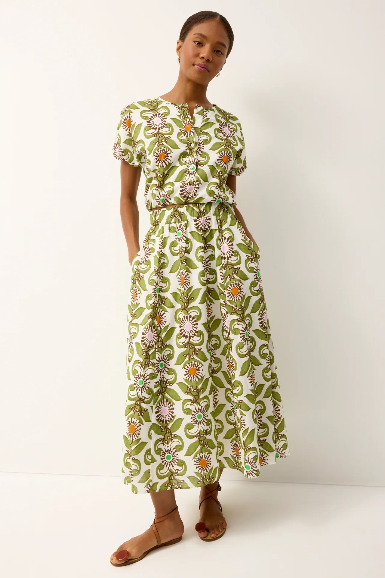 Woman wearing a green floral dress against a white background