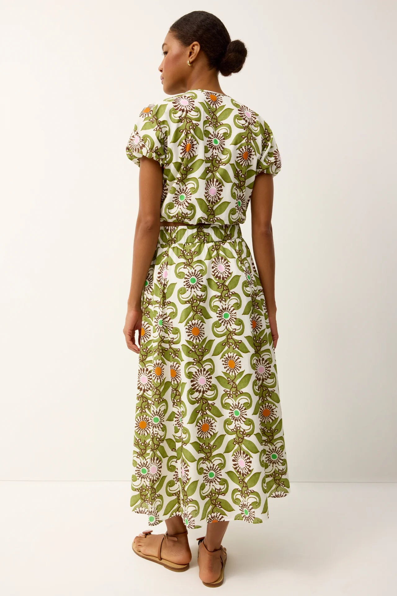 Woman wearing a green floral dress on a white background