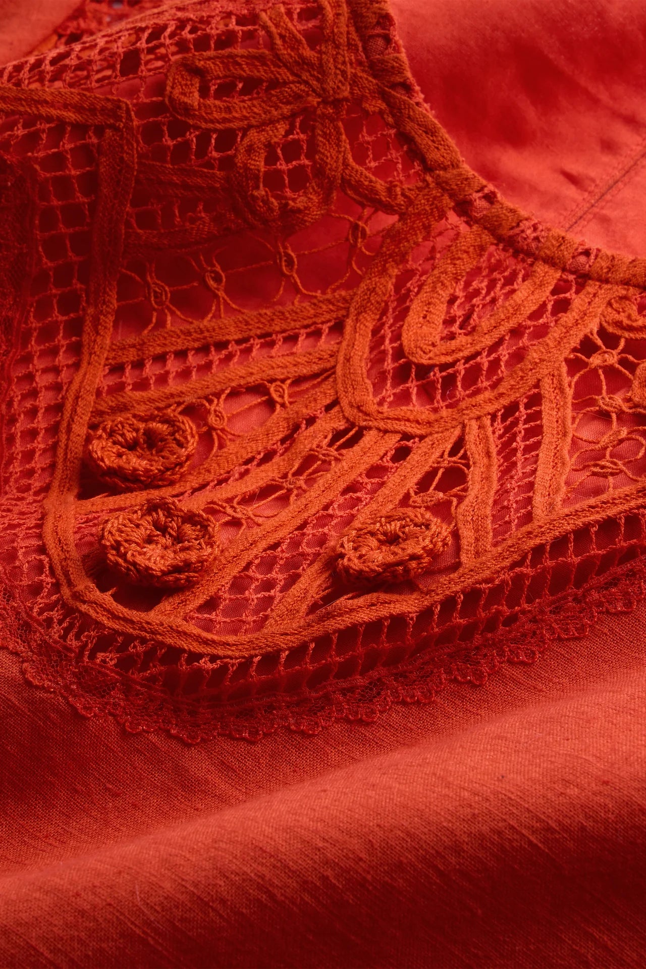 Close-up of red fabric with intricate lace detailing