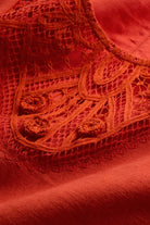 Close-up of red fabric with intricate lace detailing