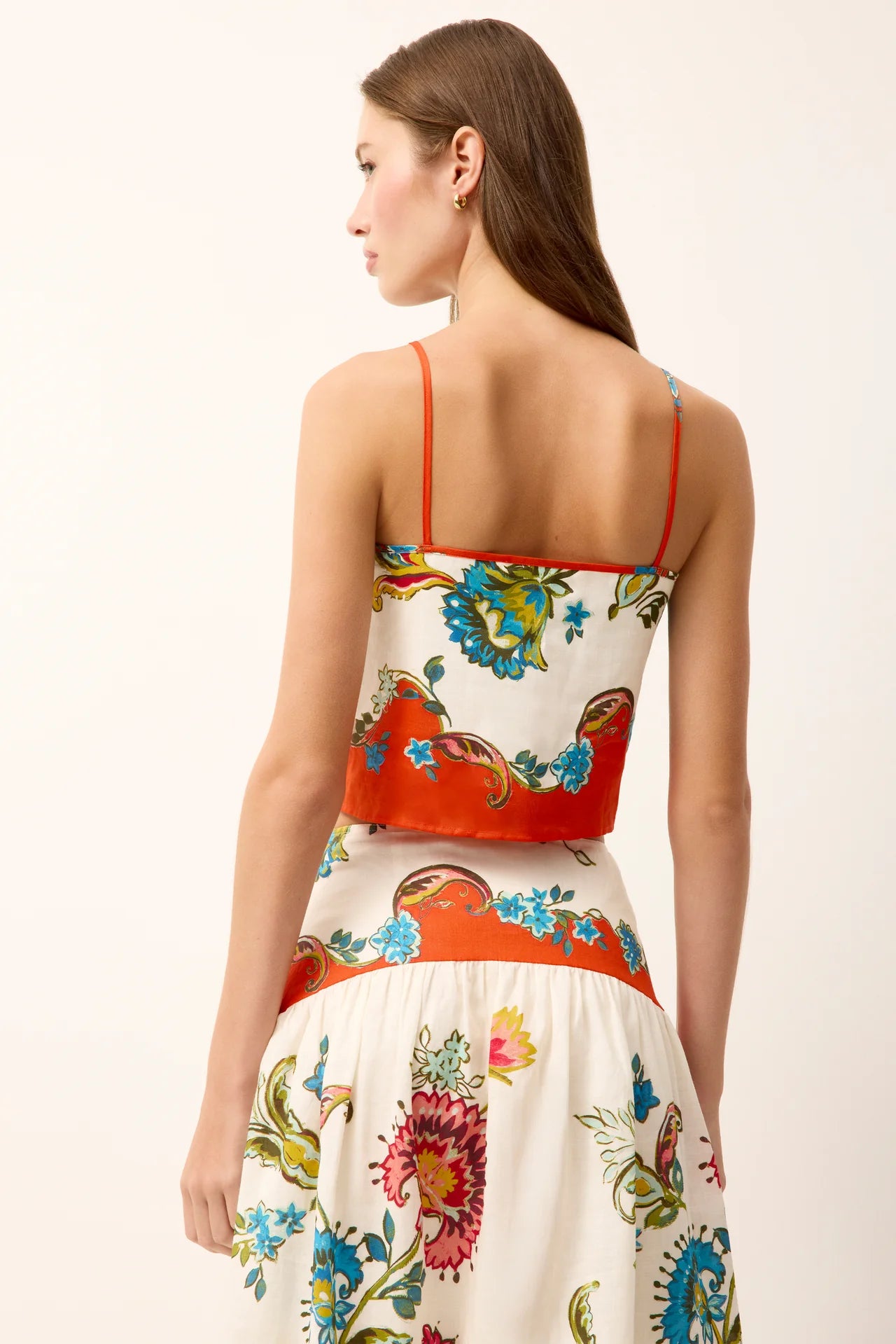 Woman wearing a colorful floral dress on a white background