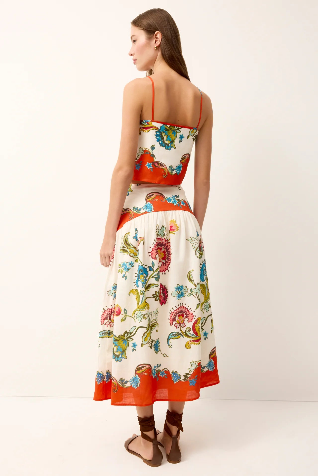 Woman wearing a colorful floral dress on a white background