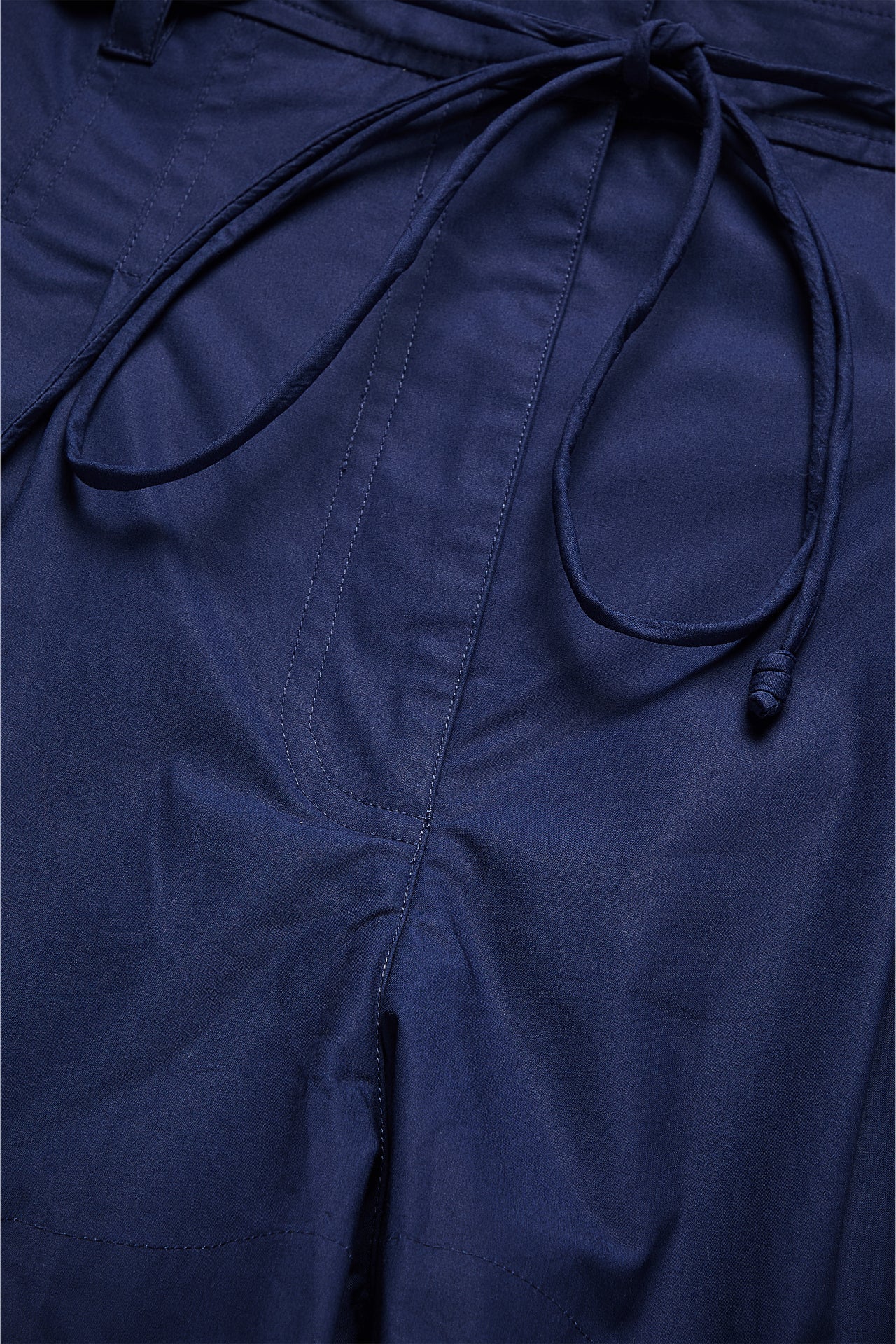 Close-up of a navy blue garment with a tie detail