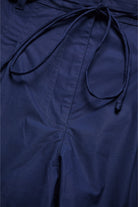Close-up of a navy blue garment with a tie detail