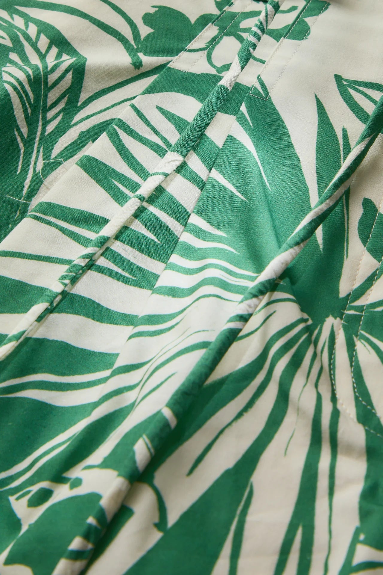 Close-up of green leaf pattern fabric on a white background