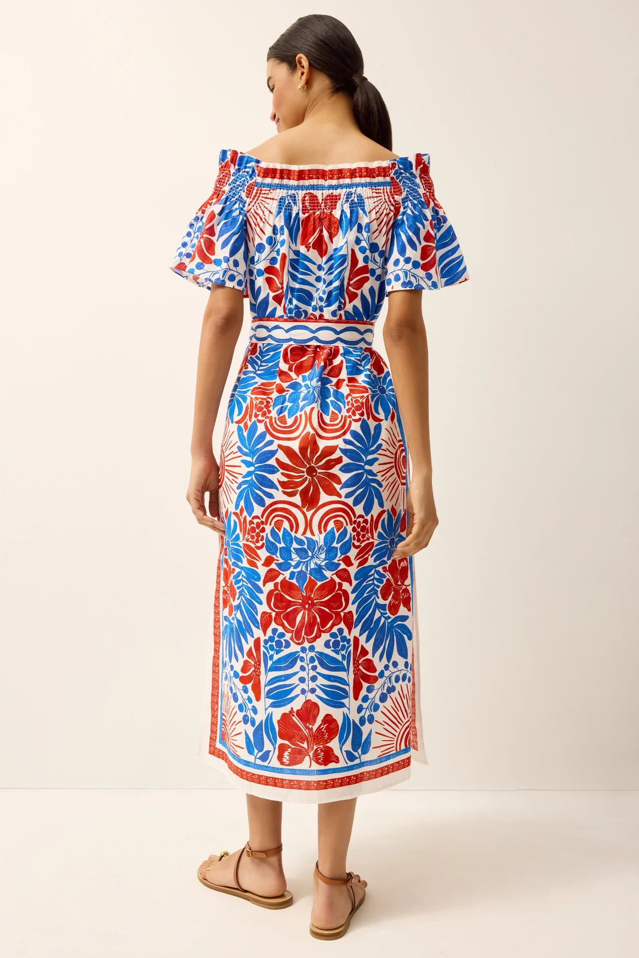 Woman wearing a colorful floral dress on a white background