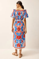 Woman wearing a colorful floral dress on a white background