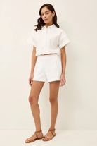 Woman wearing a white outfit with a plain background