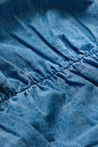 Close-up of a blue textured fabric with gathered elastic stitching.