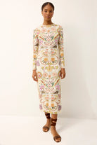 Woman wearing a long-sleeve, knee-length dress with floral patterns on a white background