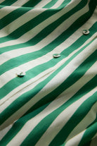 Close-up of green and white striped fabric with buttons.