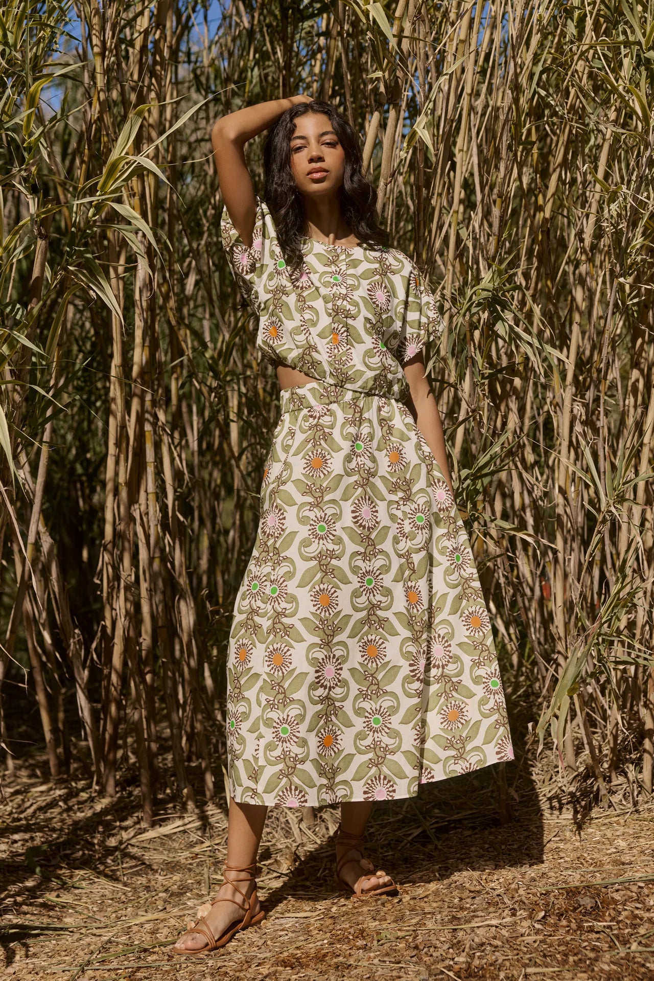 Woman in a floral dress standing in front of a natural background