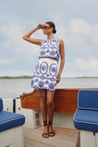 Woman in a blue and white patterned dress on a boat