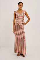 Woman wearing a red and white striped dress on a white background