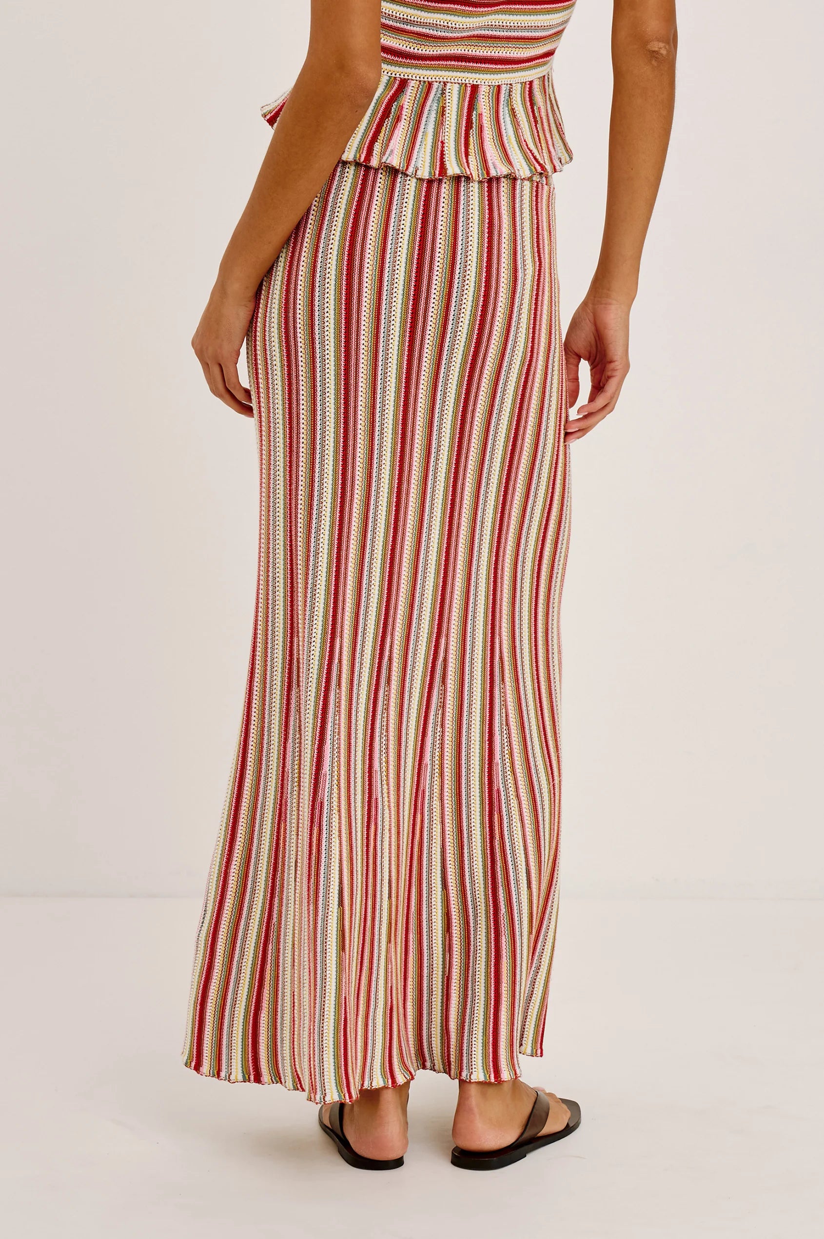 Woman wearing a red and white striped dress on a plain background