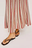 Multicolored striped skirt worn by a person on a white background