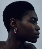 Side profile of a woman wearing earrings with a neutral background