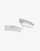 A pair of silver-toned drop earrings with a curved row of clear round-cut stones, shown on a light gray background.