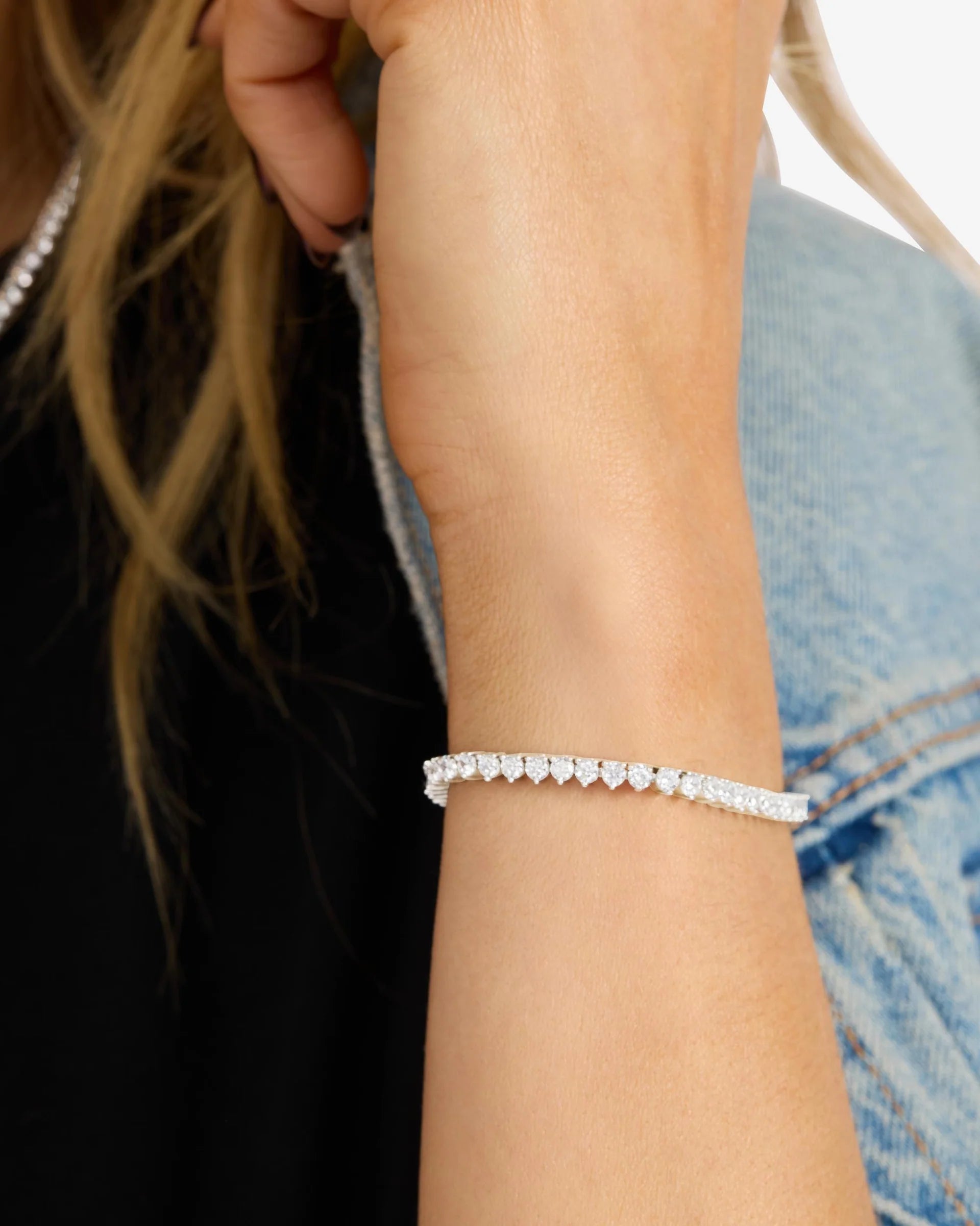 Close-up of a person's wrist wearing a delicate bracelet with a blurred background