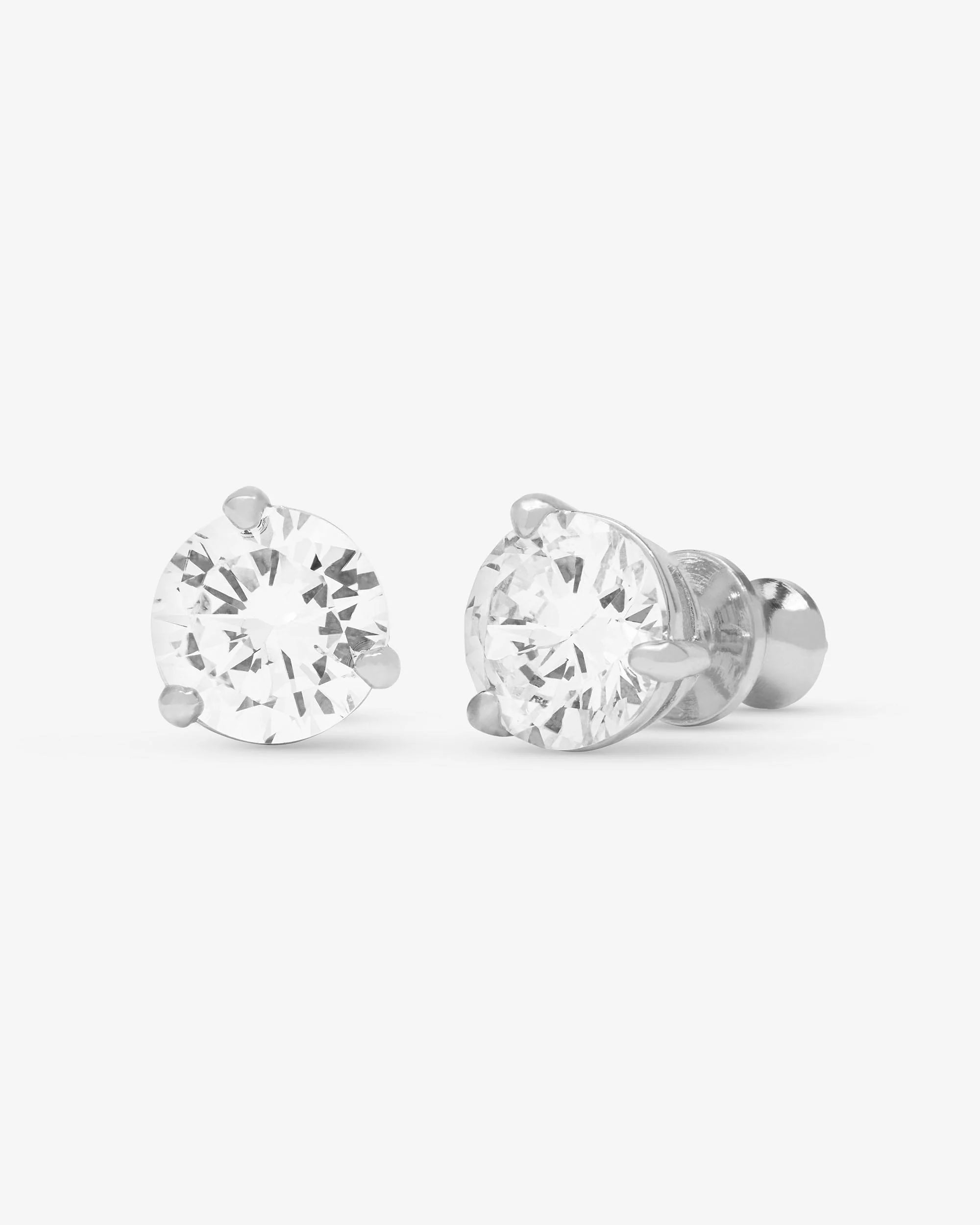 A pair of round-cut stud earrings in a silver-toned four-prong setting, shown on a clean white background.