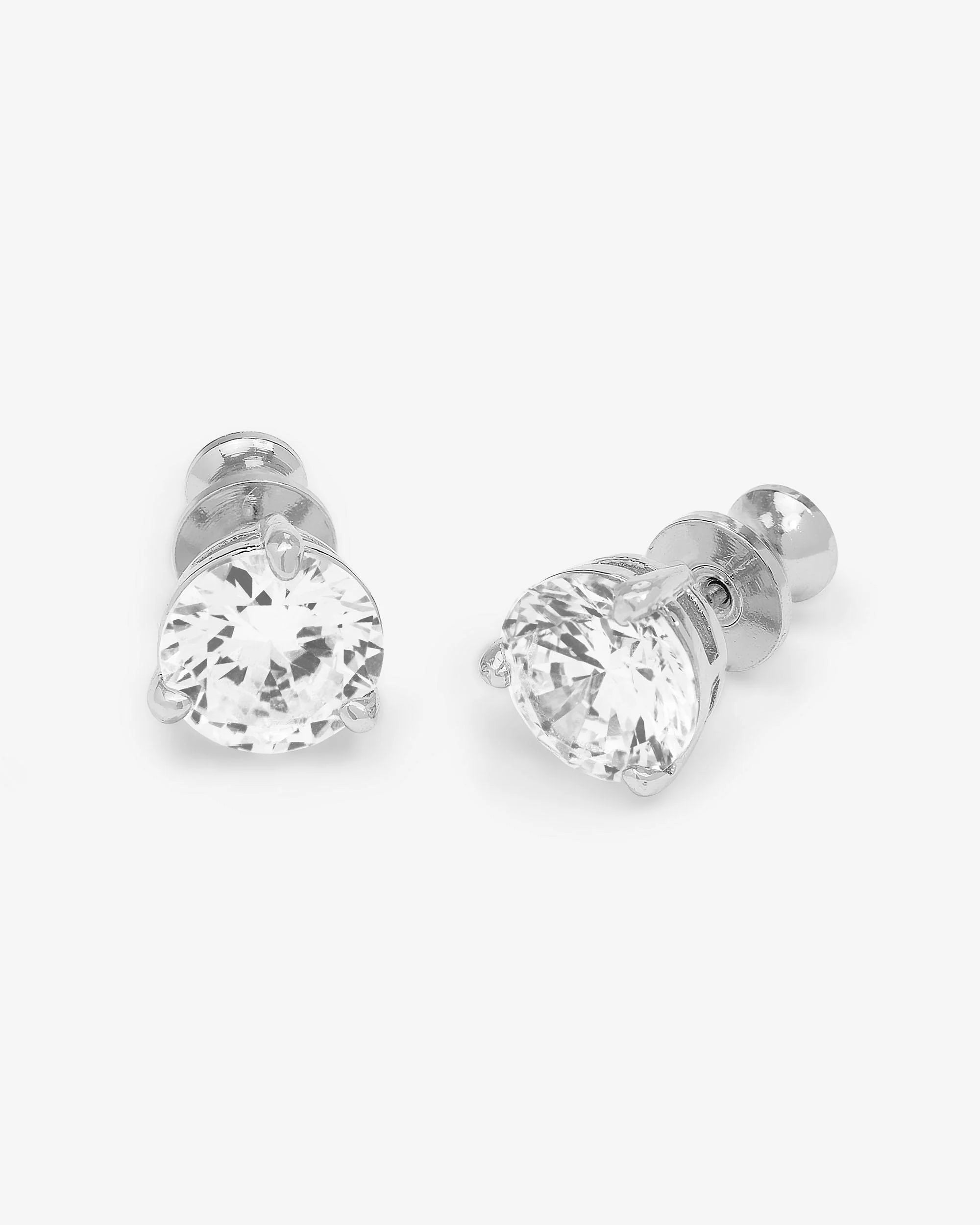 A pair of silver stud earrings with round-cut clear gemstones in a prong setting, shown on a light gray background.