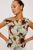 Woman wearing a floral top with a plain background
