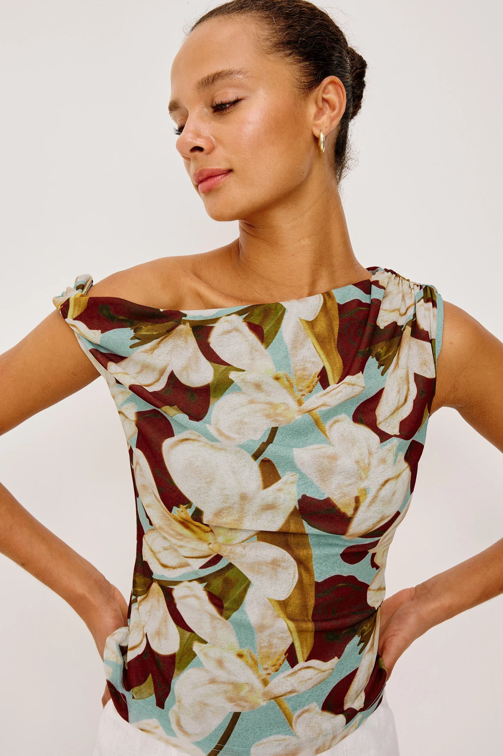 Woman wearing a floral top with a plain background