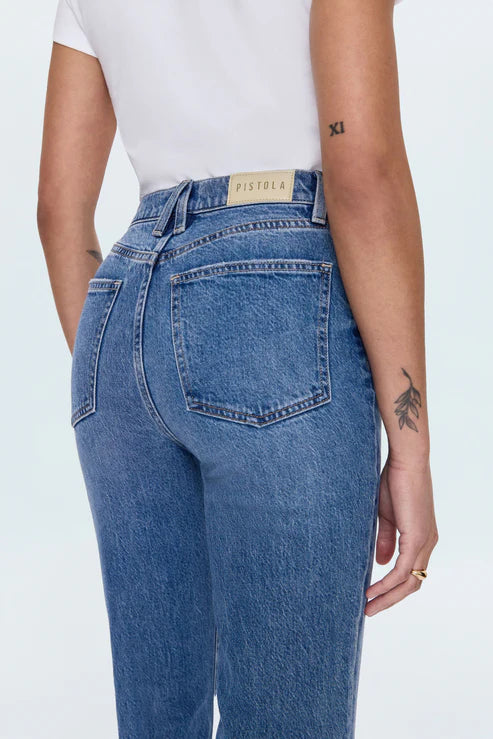 Person wearing blue jeans with a visible brand label on a white background