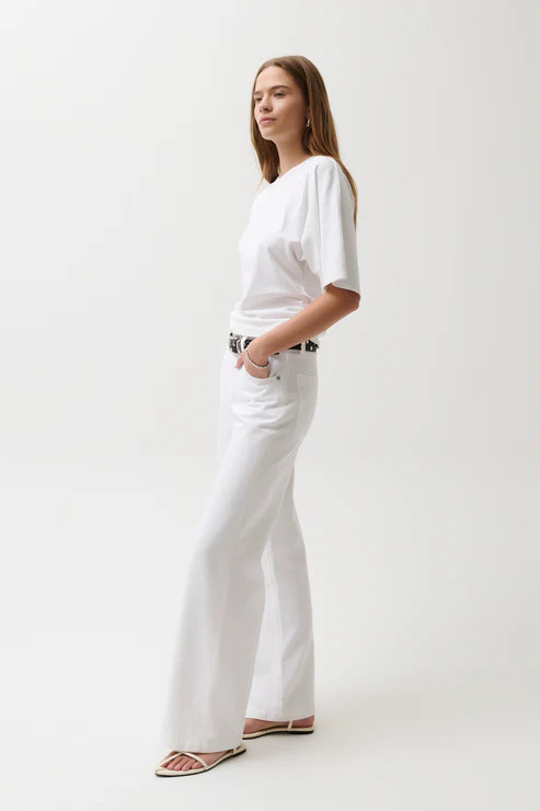 Person wearing a white t-shirt and white pants on a plain background