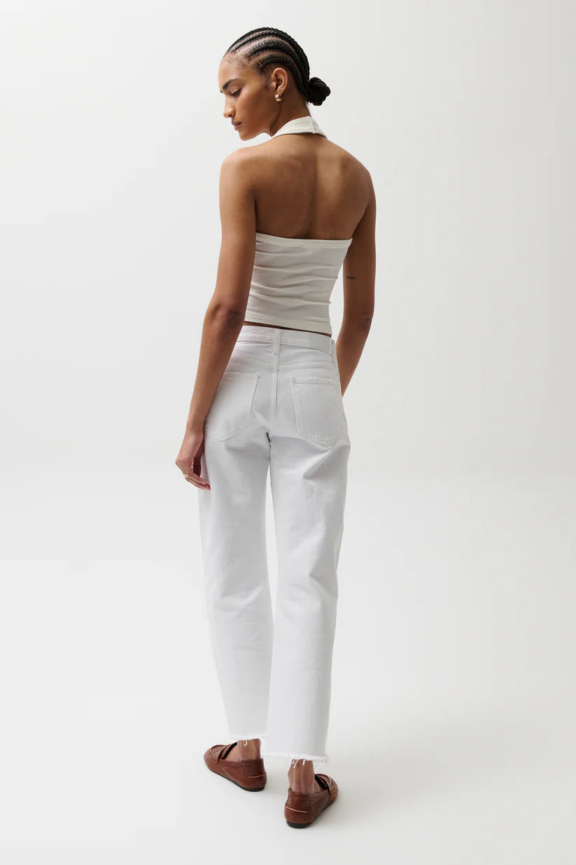 Woman wearing a white strapless top and pants on a white background