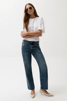 Woman wearing a white t-shirt and blue jeans on a white background