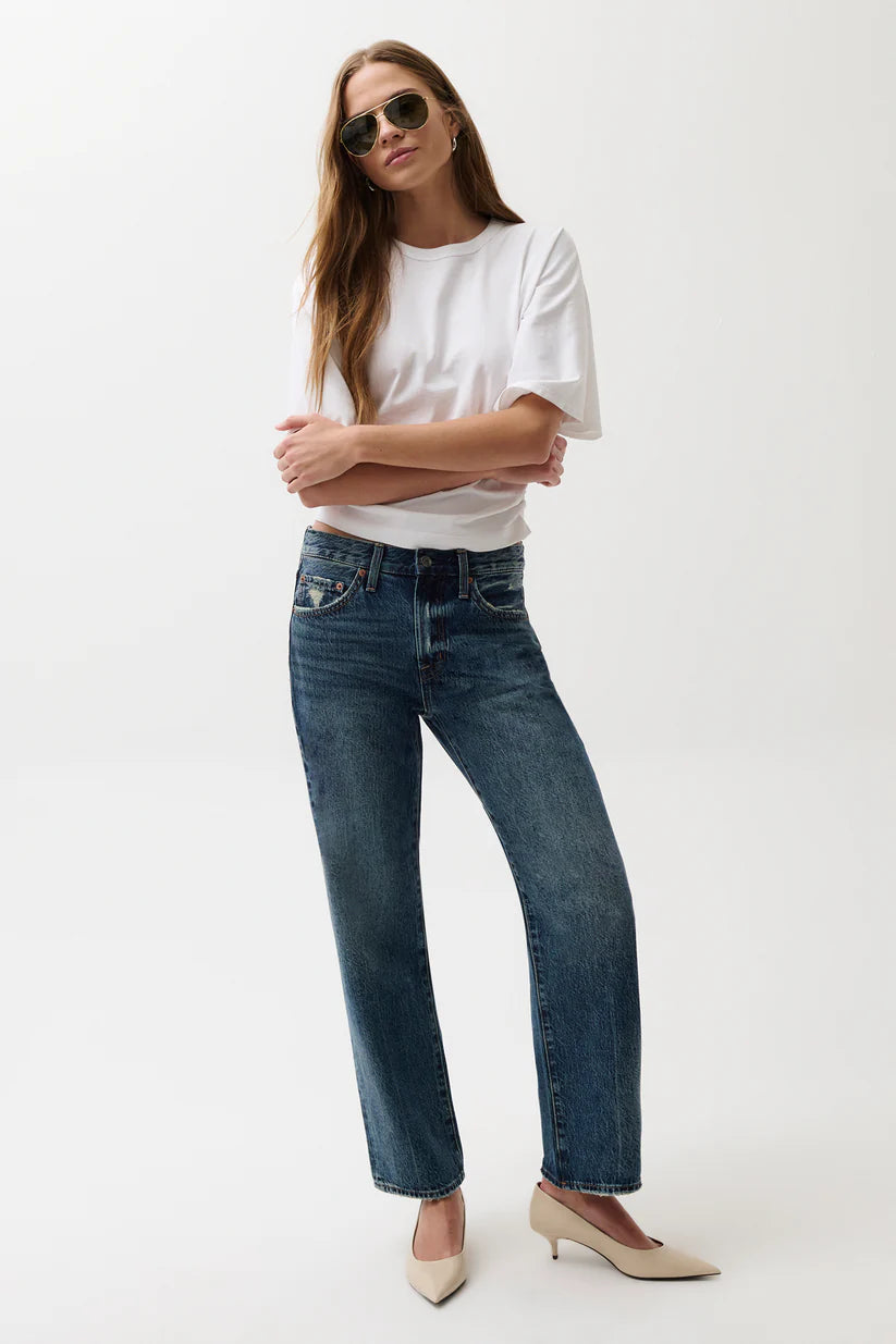 Woman wearing a white t-shirt and blue jeans on a white background