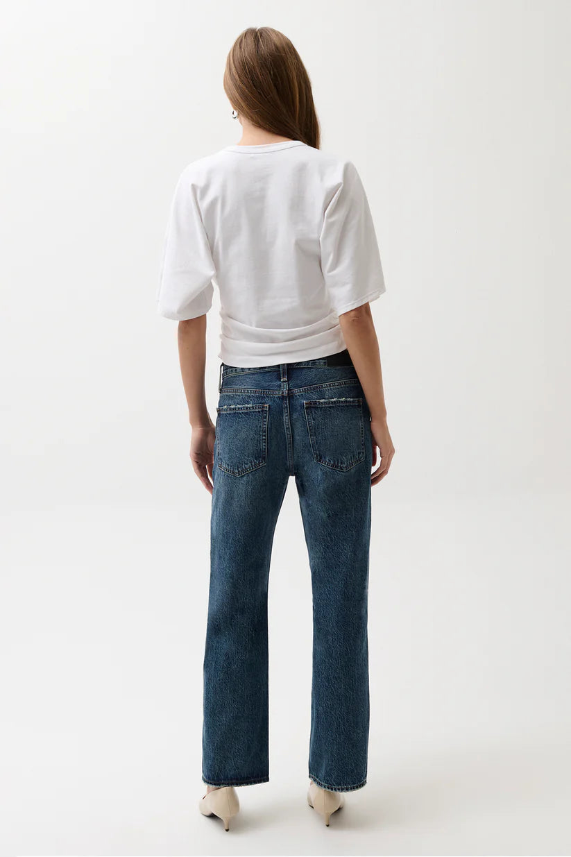 Person wearing a white shirt and blue jeans on a white background