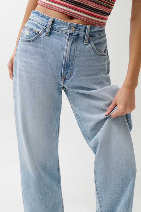 Light blue jeans worn by a person on a plain background