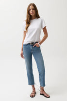 Woman wearing a white t-shirt and blue jeans on a white background
