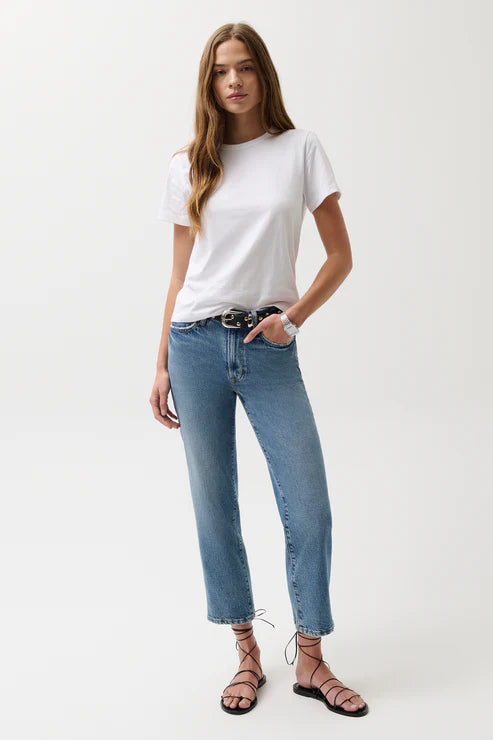 Woman wearing a white t-shirt and blue jeans on a white background