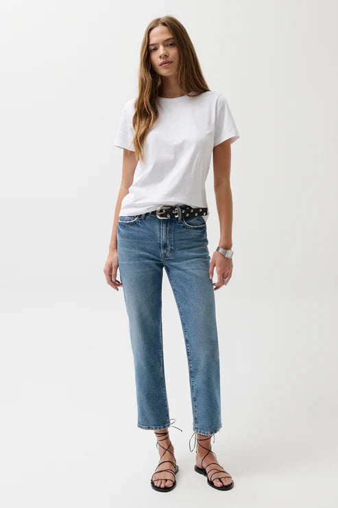 Woman wearing a white t-shirt and blue jeans on a white background