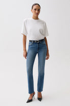 Woman wearing a white t-shirt and blue jeans on a white background